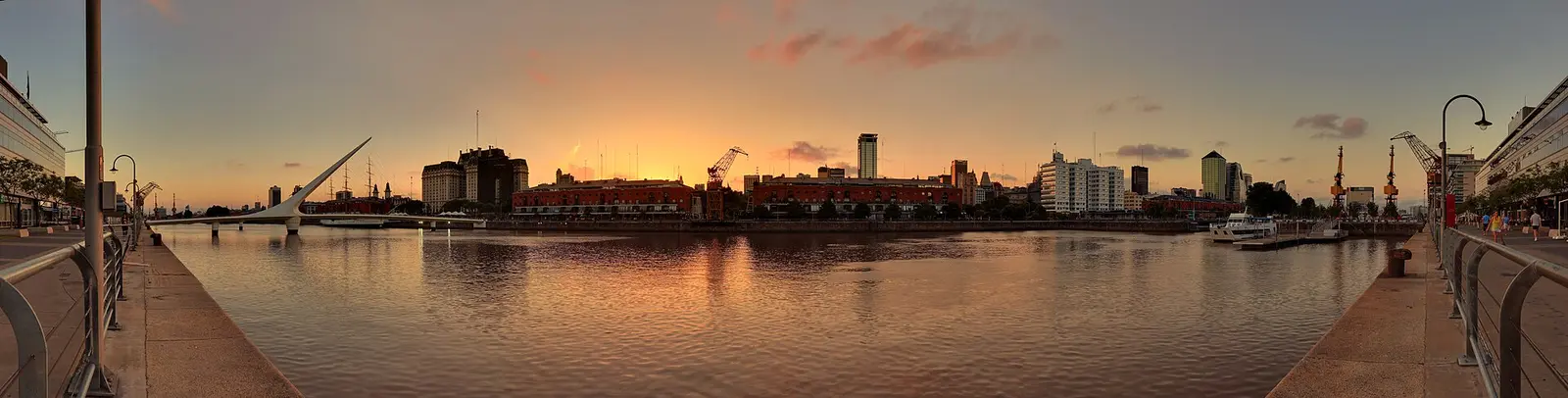 Puerto Madero waterfront in Buenos Aires at sunset with warm sky reflected in the water