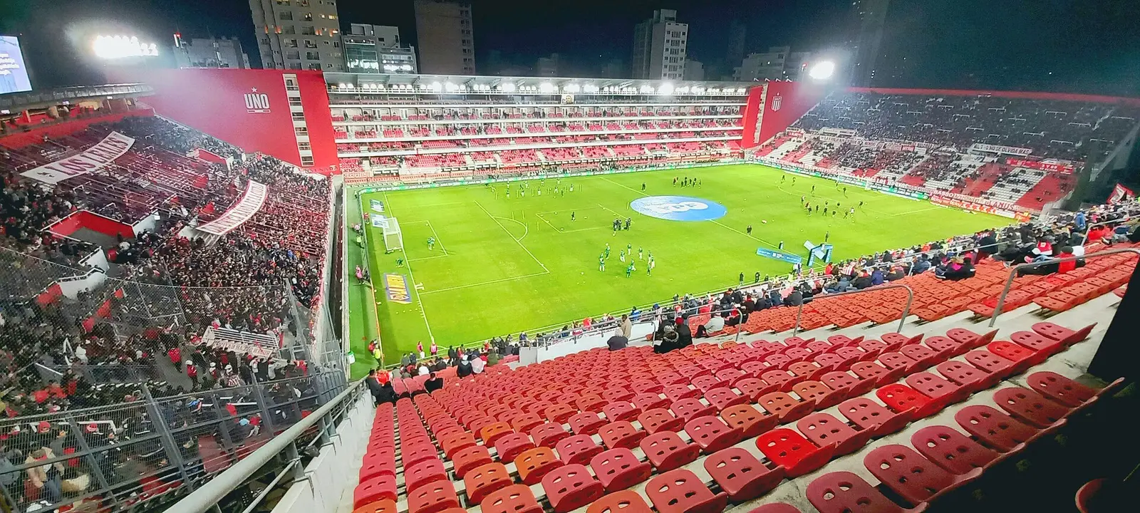 Red seats and pitch of the Jorge Luis Hirschi stadium in La Plata before a match at night