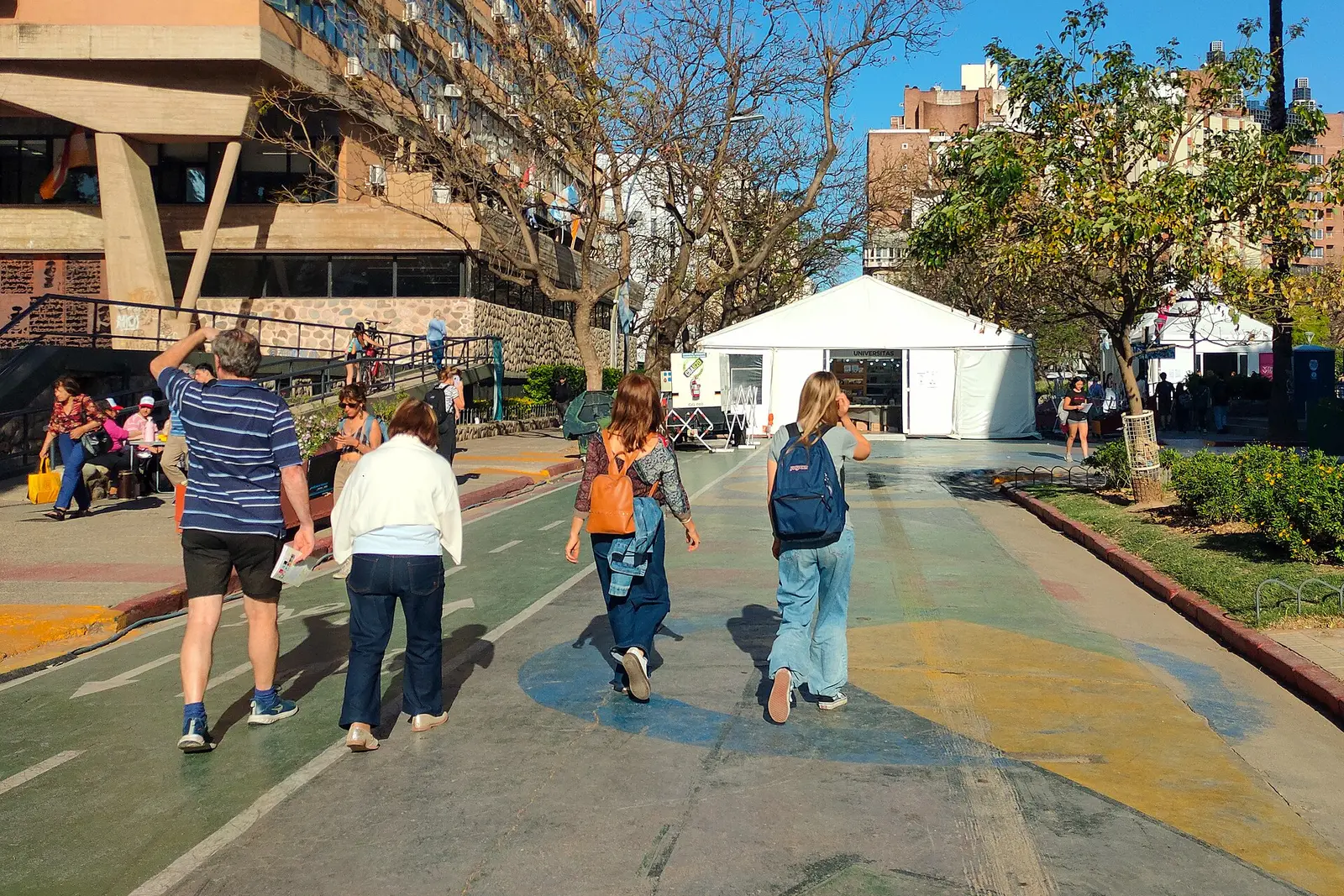 White fair tents of the Feria del Libro Córdoba 2025 on the Supermanzana Intendencia with passers-by