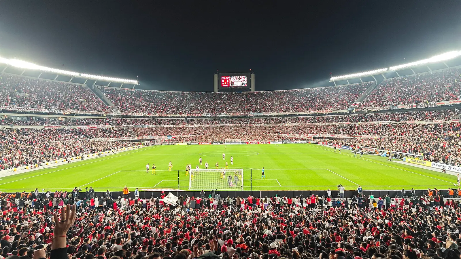 Estadio Monumental of River Plate full of spectators at night under floodlights