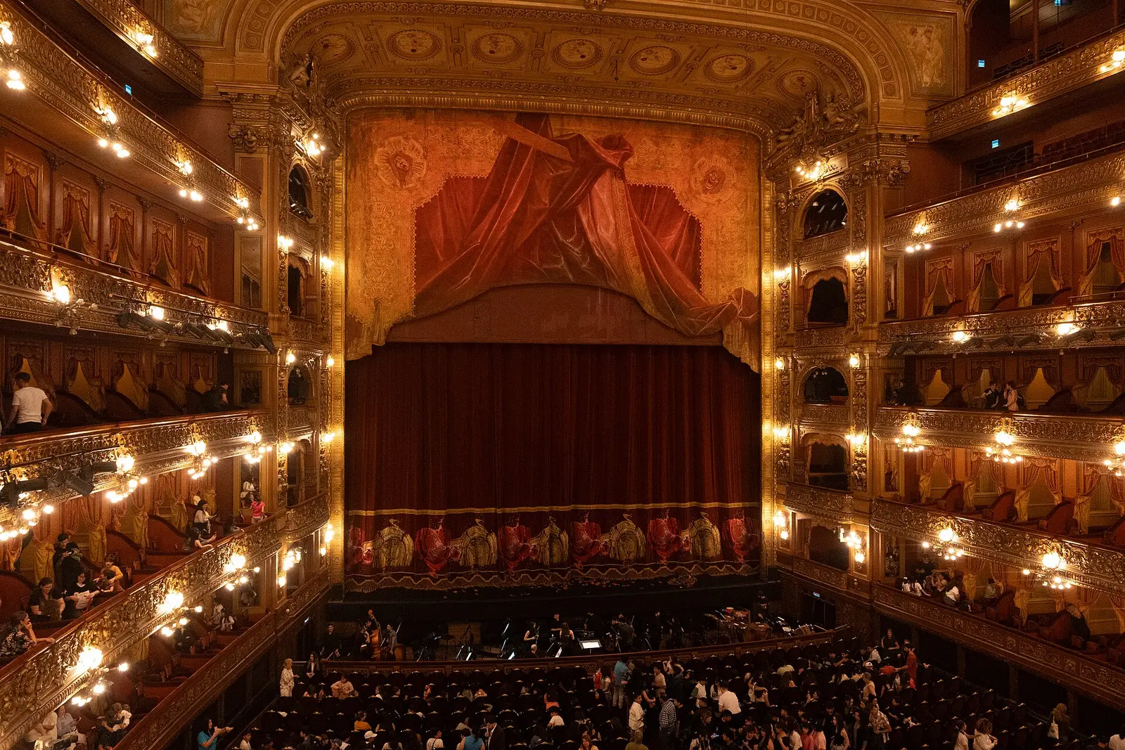 Interior of the Teatro Colón auditorium with gilded tiers and red stage curtain